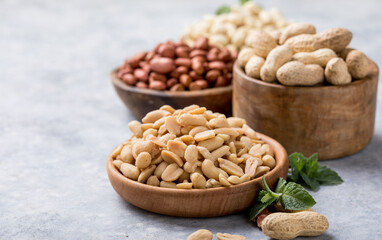 Roasted salted peanuts. Crispy nuts in bowl on stone table.