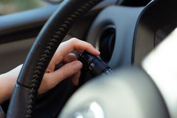 Woman's hand switching headlights off  in car, close up shot