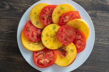 Colorful summer salad with tomato and nectarines, close up. Top view.