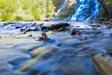Waterflow over stone and Waterfall on Background