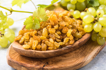 Golden raisins  in bowl on stone background, table top view. Dried fruit, healthy snack food