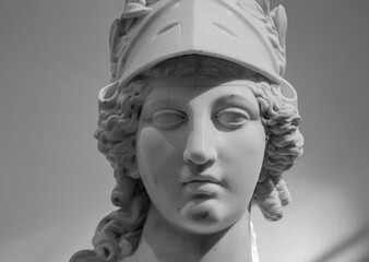 Greek ancient statue of goddess Athena. Woman marble head in helmet sculpture