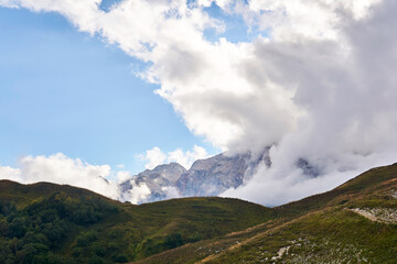 Fototapeta na wymiar mountain landscape with clouds rising from the valley beyond the pass