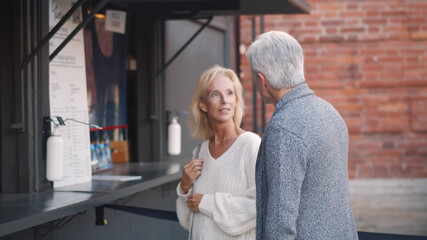 Senior couple reading menu on fast food truck outdoors