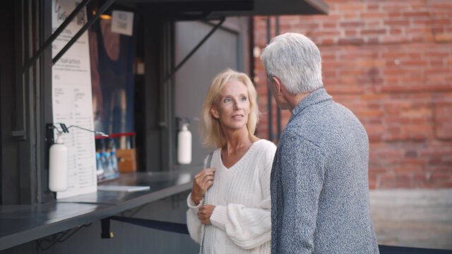 Senior Couple Reading Menu On Fast Food Truck Outdoors