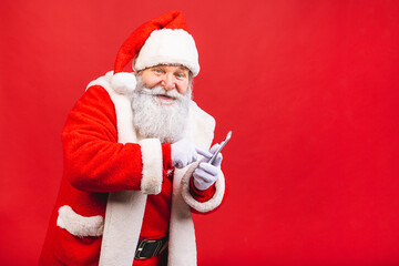 Portrait of nice attractive handsome amazed Santa using phone gadget 5g fast speed blog blogger browsing multimedia isolated over red background.