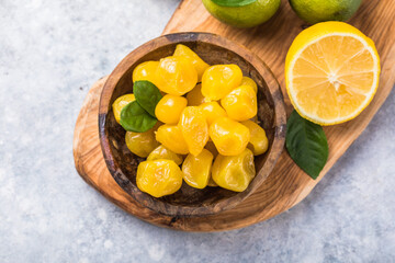 Сandied fruit, dried kumquat  with lemon flavor in bowl on stone table background.