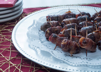Bacon Wrapped Appetizers on Platter with Stack of Plates