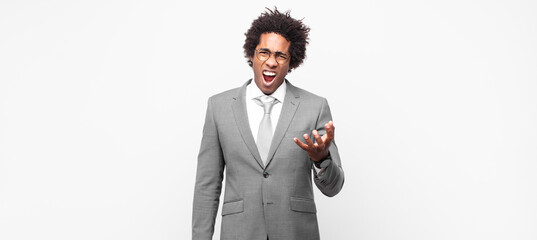 black afro businessmanlooking angry, annoyed and frustrated screaming wtf or what’s wrong with you