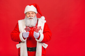 Fototapeta na wymiar Santa Claus standing isolated on red background. Christmas and new year concept.