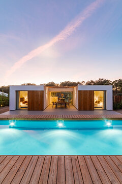 Modern house with garden swimming pool and wooden deck