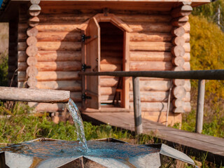 Fototapeta na wymiar Holy spring and wooden house with plunge font pool for ablutions, relaxing in a natural park.