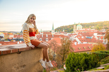 Fototapeta na wymiar Young woman on red roof background in old town of Prague in Czech republic