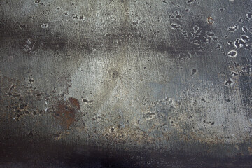 Abstract landscape of peeling grey paint on a metal plate. Rusty and stained metal surface with weld burns and scratches and stains. Artistic texture background.