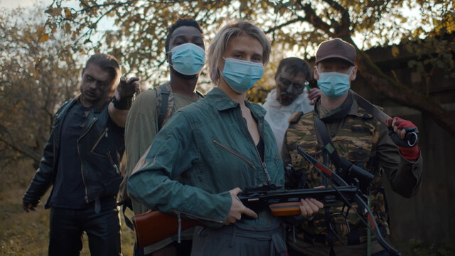 Zombie hunter team in safety mask with weapon and two monsters on background
