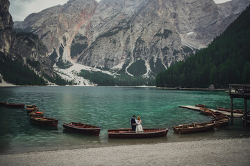 The wedding couple stands on shore of huge wide transparent turquoise aquamarine green lake in...