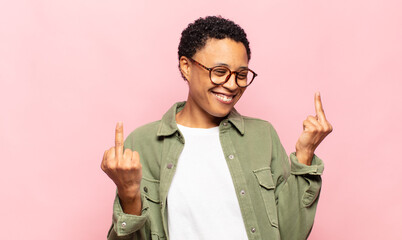 afro young black woman feeling provocative, aggressive and obscene, flipping the middle finger,...