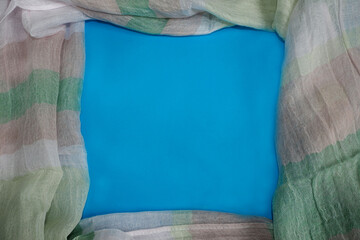 pastel linen fabric in light colors concave blue background top view