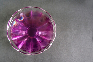 berry lilac jelly in a glass vase on a black background top view . wild berry jelly made at home