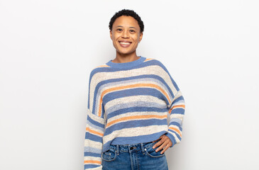 afro young black woman laughing shyly and cheerfully, with a friendly and positive but insecure...