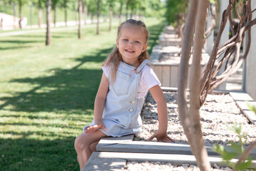 Little girl in an urban setting smiles at the camera.