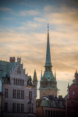 Fototapeta na wymiar Backlight profiles of buildings and church in the old town Gamla Stan in Stockholm at sunrise