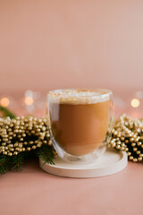 cup of coffee cocoa with cinnamon standing on the grown celebration table with christmas lights and fir-tree still life