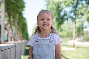 a little girl smiles, shows her teeth. large portrait.