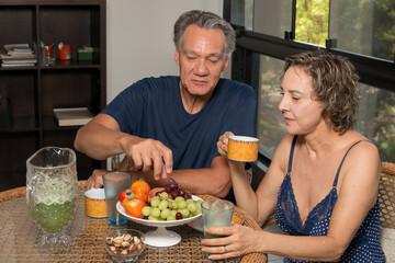 Loving Mature Couple Enjoying a Lite Breakfast in there Sunroom

