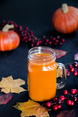 Halloween cocktail, pumpkin orange drink with spices. Dark vintage dirty background. Creative atmospheric decoration