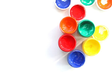 Open gouache jars on white background,top view.Copy space.advertising of master classes for painting and drawing lessons