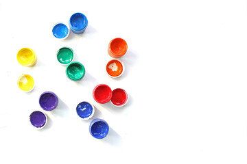 Opened cans of paint. View from above. colorful finger paints over white background