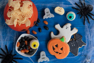 Fototapeta na wymiar Halloween candy and snacks on decorated table. Top view