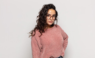 pretty young woman looking proud, confident, cool, cheeky and arrogant, smiling, feeling successful