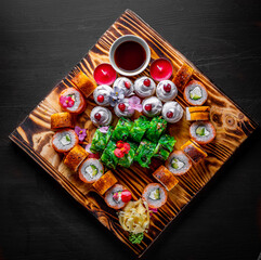set of sushi roll with salmon, avocado, cream cheese, cucumber, rice, caviar, eel, tuna on wooden table