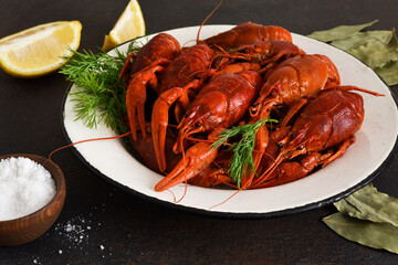Red crayfish with dill, bay leaf and lemon in a plate.