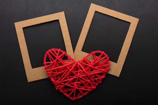 two frames for photos and a red heart. Kraft cardboard frame template on black background. Concept for valentine's day, love, wedding