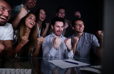 happy business team looking at computer monitor