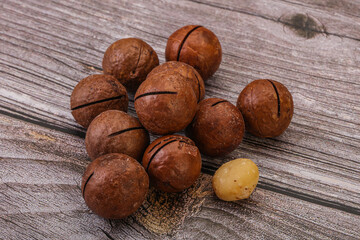 Brown macadamia nut heap over background
