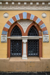 arched window with stucco elements on an old facade. Vertical photo