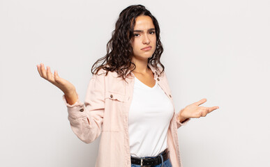 pretty young woman looking puzzled, confused and stressed, wondering between different options,...