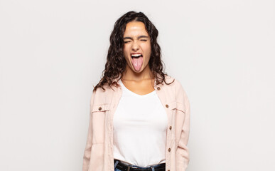 pretty young woman with cheerful, carefree, rebellious attitude, joking and sticking tongue out,...
