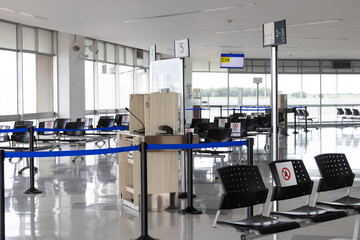 Empty waiting room at an airport during COVID-19 pandemic with social distancing signs on chairs