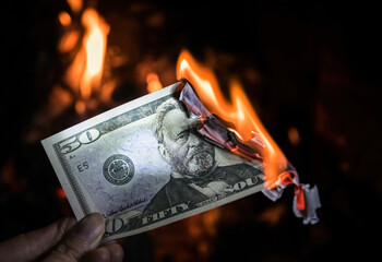 Burning fifty dollar bill. US financial crisis, lockdown and inflation