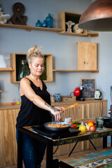 Plano medio de hermosa mujer cocinando plato típico oriental. Mujer cocinando comida oriental....