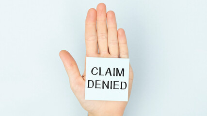 Businessman holding a card with text Claim Denied