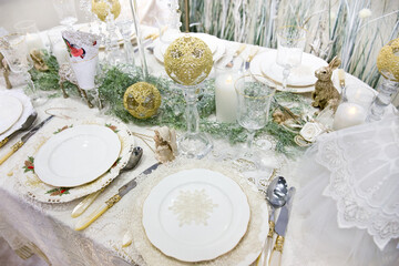 New Year's Eve Dinner. Nicely served table. White crockery and lace tablecloth.