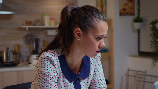 Woman squiting eyes because of exhaustion while working on a project late at night from home. Busy employee using modern technology network wireless doing overtime for job reading writing, searching