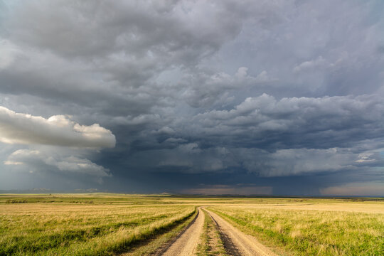 Dirt road with storm clouds and dramatic sky
