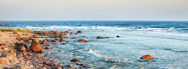 Panoramic view of the Baltic sea shore, Hiiumaa island, Estonia. Soft sunset light. Stones, waves and water splashes close-up. Travel destinations, nature, eco tourism